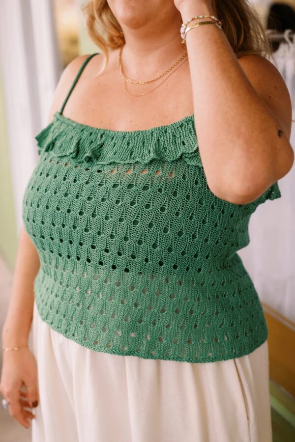 Lady wearing green knitted shoe string frilly top
