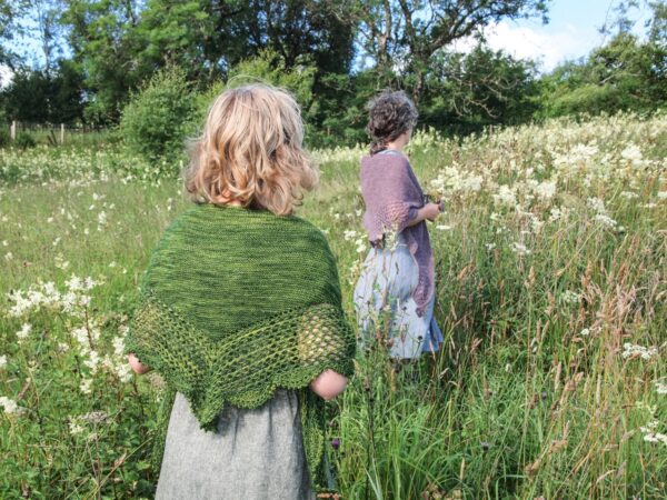 Ladies wearing shawls in a field of flowers
