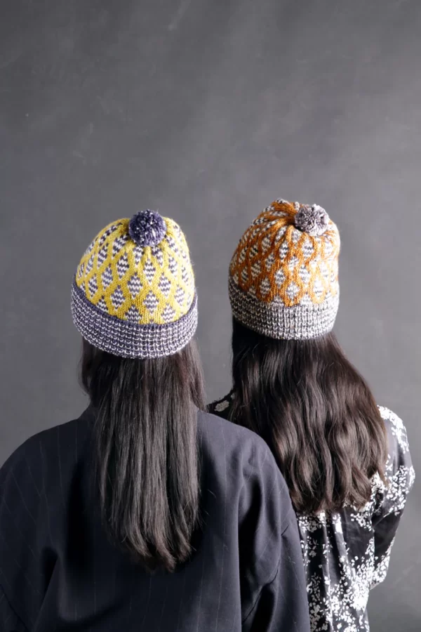 Pompom beanies with knitted shape patterns